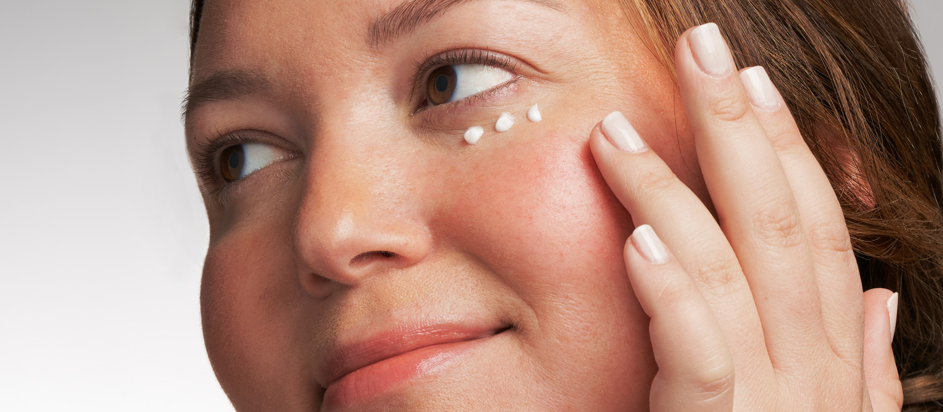 Kvinna som applicerar NEOSTRATA ögonkräm