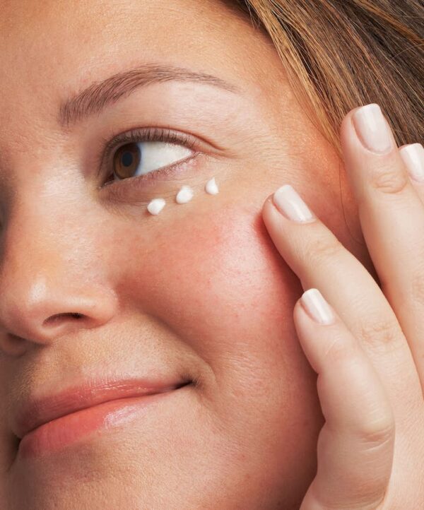 30141_neostrata_pha_eye_cream_v4.jpg Kvinna applicerar produkt under ögat och håller handen mot sin kind.