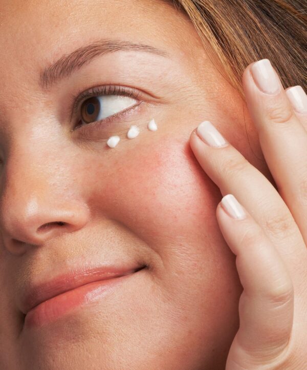 30119_neostrata_brightening_eye_cream_v4.jpg Kvinna applicerar tre prickar av produkt och håller handen mot ansiktet.