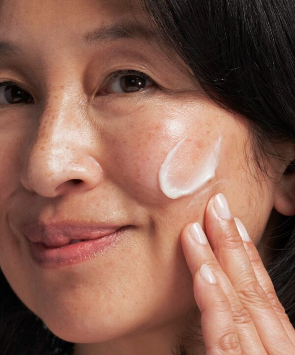 30131_neostrata_skin_brightener_spf_25_v4.jpg Kvinna applicerar produkt på kind med sin hand.