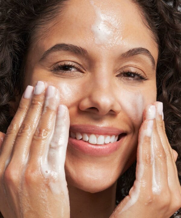 30150_neostrata_foaming_glycolic_wash_v4.jpg Kvinna rengör ansiktet med neostrata produkt.