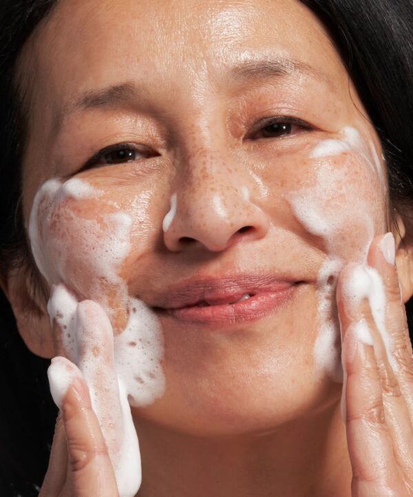 30146_neostrata_skin_active_exfoliating_wash_v4.jpg Kvinna applicerar produkt i ansiktet med händerna.